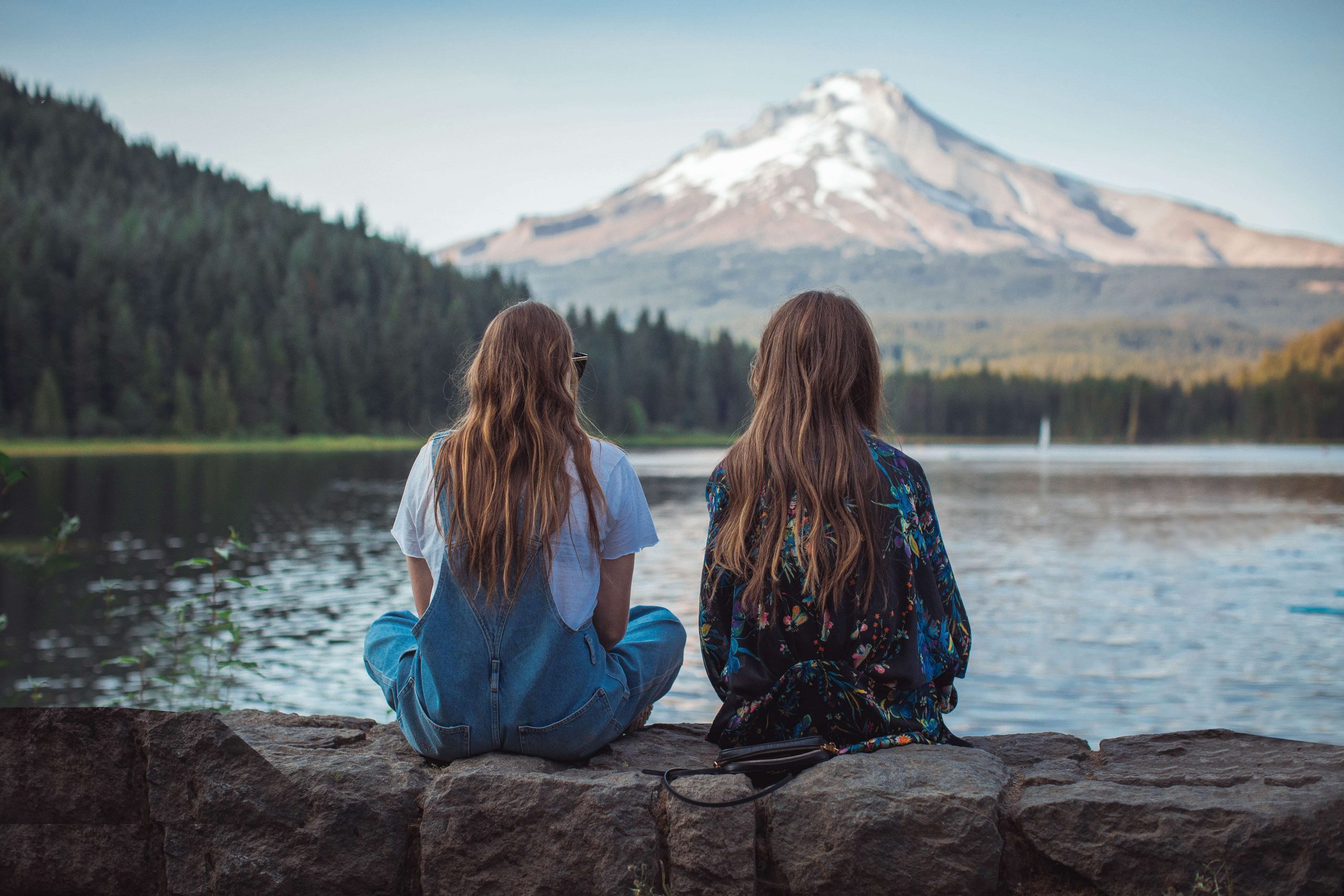 Two girls sitting by the lake, , happy after moving from California to Oregon